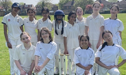 U13 girl cricket team posing on the lawn